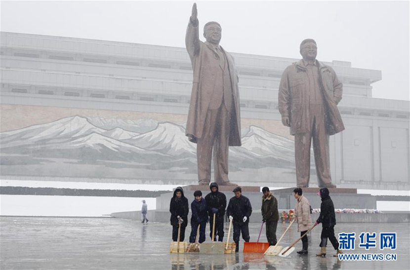 11月25日，在朝鮮首都平壤，民眾在萬壽臺廣場清掃冰雪。 新華社記者朱龍川攝